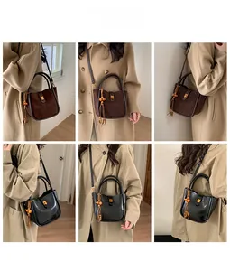 Détail du sac seau en daim avec glands en perles de bois et boucle en métal chic