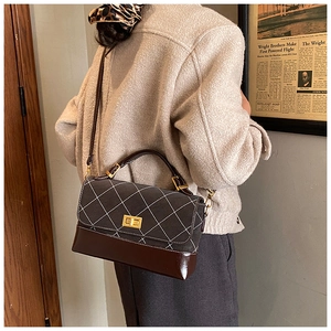 Close-up of retro color-block handbag with diamond stitching and golden turn-lock