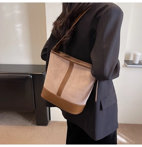 Detail of retro bucket bag showing contrast between beige suede and brown leather trim