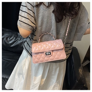 Détail d'un sac à main rose en cuir verni matelassé avec chaîne argentée et fermoir