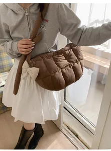 Détail du sac matelassé marron avec nœud décoratif crème et coutures en treillis chic