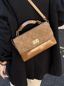 Brown quilted crossbody bag with top handle and gold twist lock shown on a model
