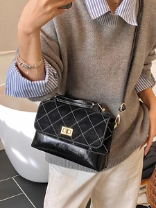 Classic black quilted crossbody bag with gold hardware and suede splicing detail