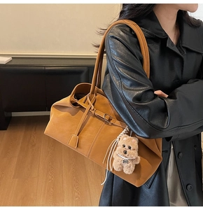 Detail of soft camel leather tote bag with ribbon tie and pearl teddy bear charm