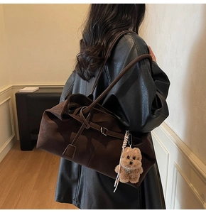 Brown matte tote bag with teddy bear charm shown on model in black leather jacket