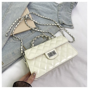Détail du petit sac blanc matelassé avec fermoir rotatif argenté et bandoulière