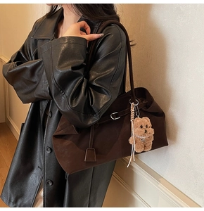 Detail of dark brown faux suede tote bag with a cute plush bear charm decoration