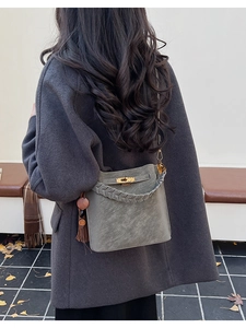 Detail of vintage matte bucket bag with woven handle and metallic lock in smoky grey