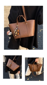 Detail of a brown tote bag featuring unique wooden bead tassels and smooth leather texture