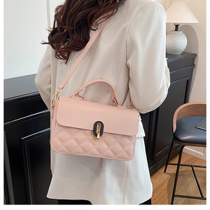 Detail of light pink quilted handbag with gold-tone twist lock and slim shoulder strap