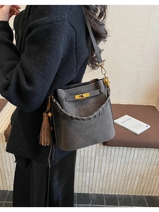 Dark grey matte faux leather bucket bag with woven handle and gold twist lock clasp