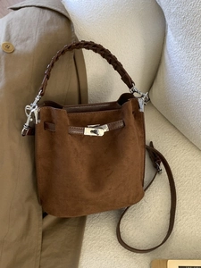 Retro Wildleder Eimertasche in Dunkelbraun mit geflochtenem Griff auf Sofa