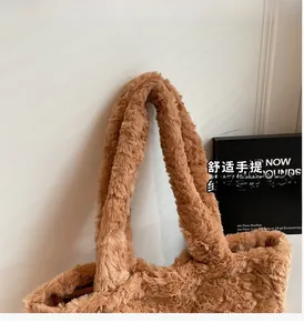 Gros plan des poignées épaisses en peluche brune d'un sac cabas doux en fausse fourrure