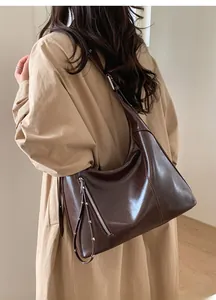 Macro detail of deep brown vintage hobo bag with tassel zipper and wax leather texture