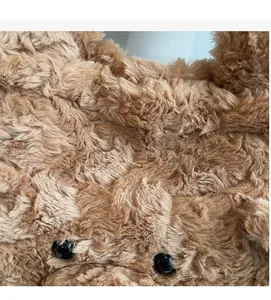 Gros plan sur la texture en peluche brune et les détails des yeux d'ours sur le sac