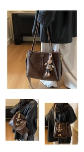 Detail of vintage brown tote bag with textured wide strap and rabbit plush charm