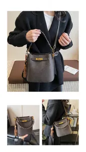 Close-up of retro bucket bag with woven handle, side tassels, and gold twist lock buckle