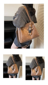 Detail view of brown vintage PU leather tote bag with woven strap and bear charm