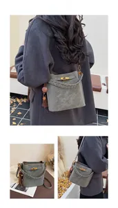 Close-up of matte faux suede bucket bag featuring woven handle and metallic lock detail