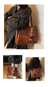 Detail of vintage brown tote bag with woven strap and cute rabbit pendant charm