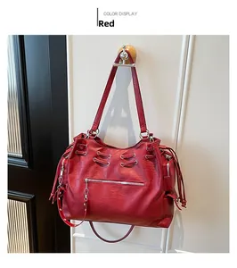 Detail of red vintage oversized tote bag with metal grommets and smooth leather texture