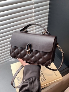 Dark brown quilted crossbody bag with gold oval twist lock and adjustable strap