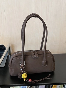 Brown leather boston shoulder bag with litchi grain texture and floral charm detail