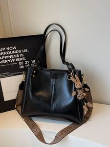 Large black faux leather tote bag with vintage geometric strap and rabbit charm
