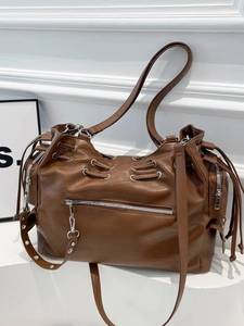 Vintage large brown PU leather tote bag with drawstring and silver hardware on white steps