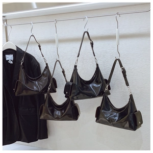 Détail du sac hobo noir brillant avec poche latérale fonctionnelle et boucle en argent réglable
