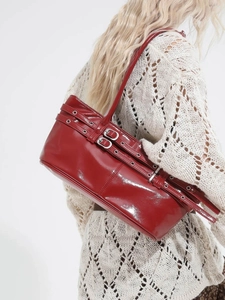 Glossy red patent leather shoulder bag with silver buckles in chic motor style