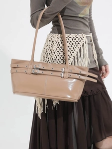Beige patent leather pleated shoulder bag with decorative belts and metal eyelets