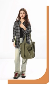Olive green canvas tote bag shown on model highlighting its large capacity and casual style