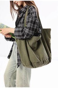 Detailed texture of olive green washed canvas tote bag with wide shoulder strap
