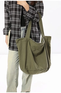 Detail of army green canvas tote bag showing large capacity and durable textured fabric