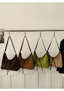 Sacs hobo vintage en daim de plusieurs couleurs présentés sur un portant en métal