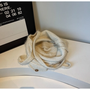 Detail of beige knit tote bag with wooden button closure and textured plush material
