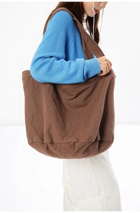 Detail view of large dark coffee canvas tote bag texture and side shoulder wear