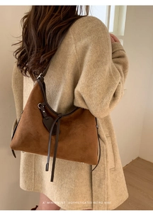 Détail du sac à bandoulière en daim camel au design rétro minimaliste avec lacets en cuir