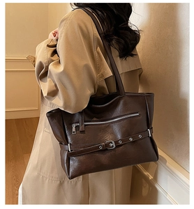 Detail view of large dark brown tote bag with zipper pocket and adjustable strap design