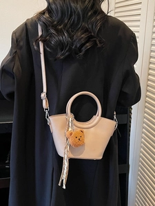 Elegant beige crossbody bag with circular handle and cute bear charm for women