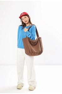 Brown canvas tote bag styled with a casual sweater and wide-leg pants for a minimal look