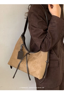 Détail du sac porté épaule vintage en daim montrant le cordon et la texture premium