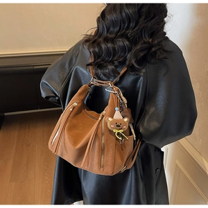 Detail of caramel leather multi-functional backpack tote with dual zippers and tassels