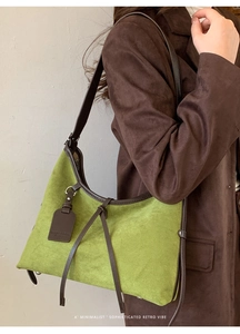 Détail d'un sac bandoulière en daim vert herbe avec bordures en cuir brun et style rétro