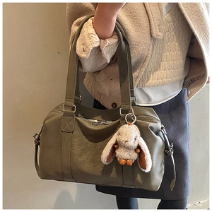 Olivgrüne Tragetasche mit Hasenanhänger im stilvollen Pendler-Look präsentiert