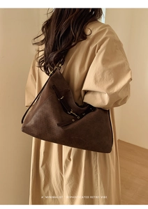 Brown woven leather shoulder bag with vintage bronze clasp on model showing side view