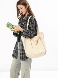 Minimalist beige canvas tote bag shown by model for casual daily commuting style