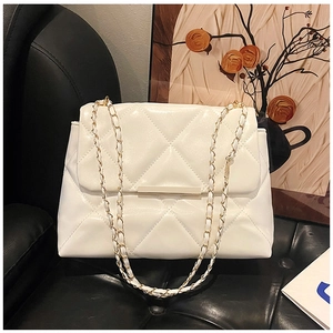 Detail of white quilted chain bag with gold metal trim and glossy finish