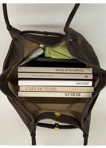 Vertical view of a large brown tote bag interior with magnetic closure and spacious storage